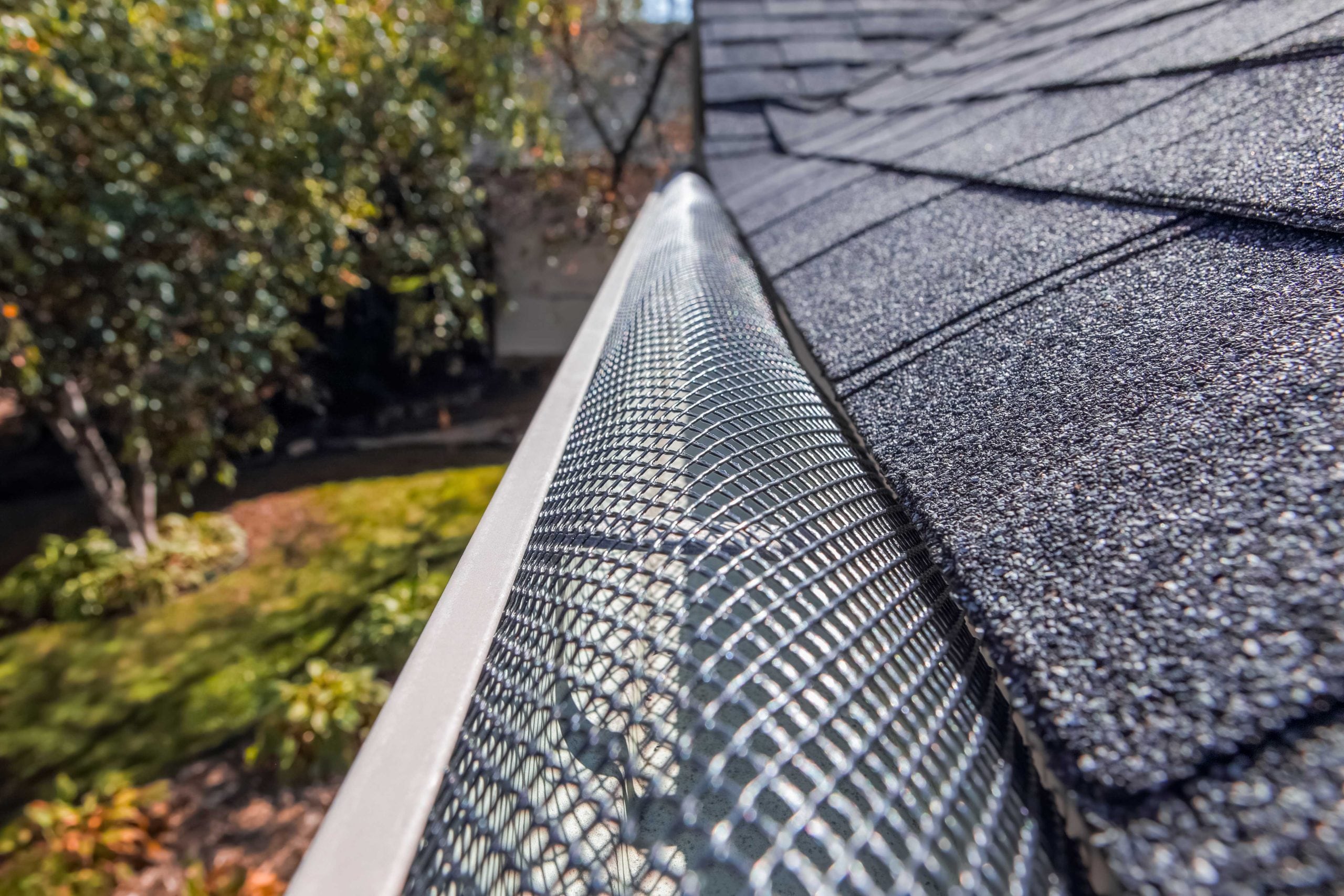 Protective gutter guard preventing falling leaves from clogging a residential gutter