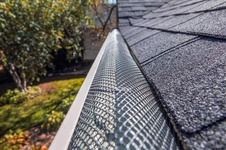 Protective gutter guard preventing falling leaves from clogging a residential gutter