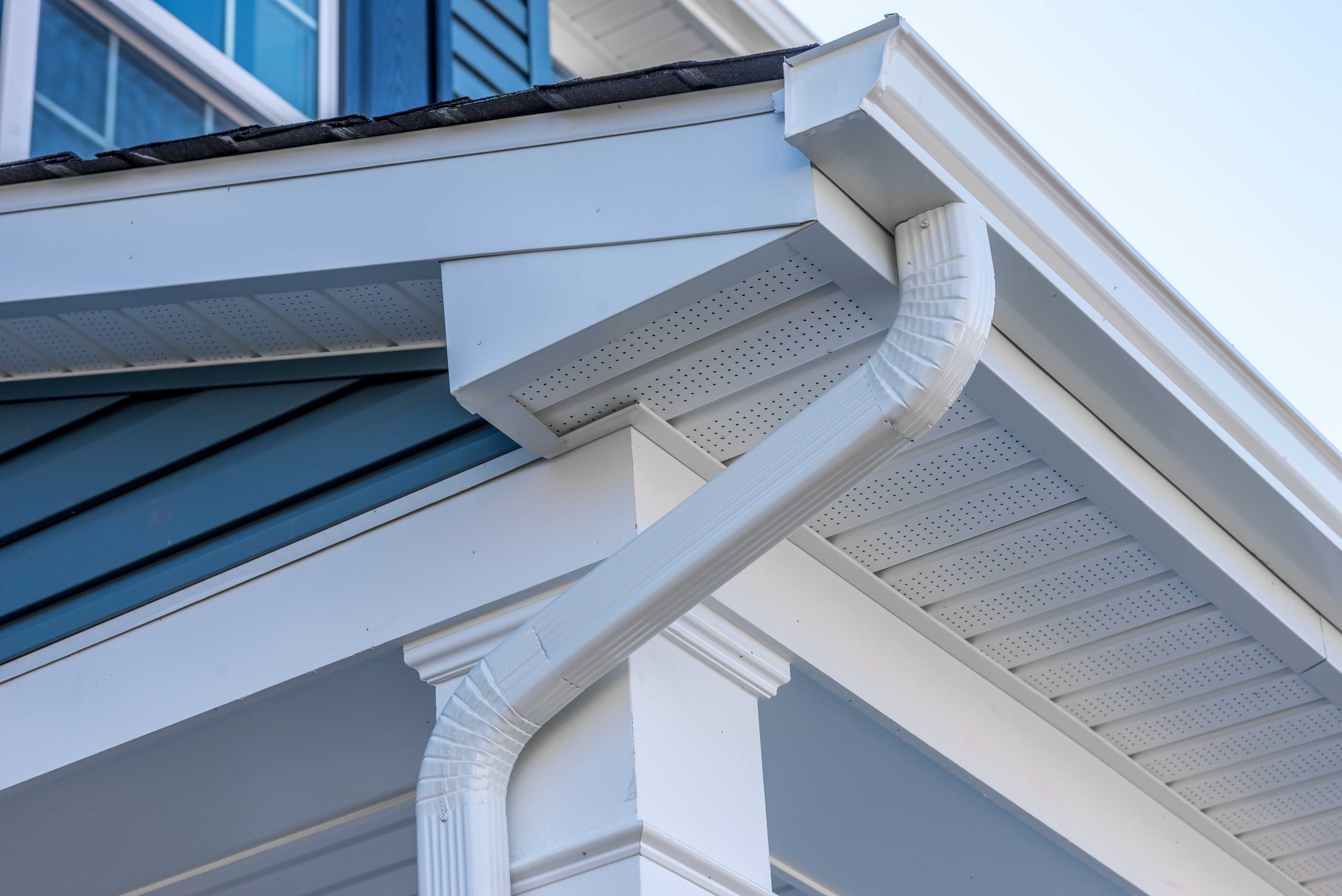 Image of a durable and lightweight Vinyl Gutter system in white color, installed on a residential house roof. The Vinyl material is resistant to rust, corrosion, and fading, making it ideal for long-lasting protection against rainwater damage.