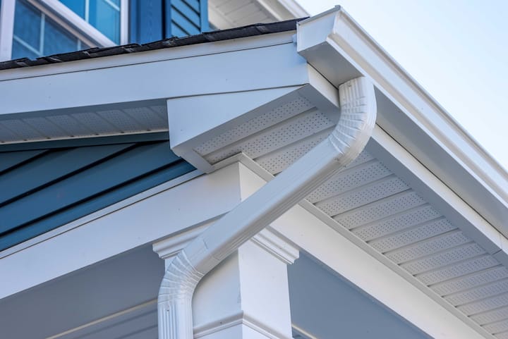 Image of a durable and lightweight Vinyl Gutter system in white color, installed on a residential house roof. The Vinyl material is resistant to rust, corrosion, and fading, making it ideal for long-lasting protection against rainwater damage.